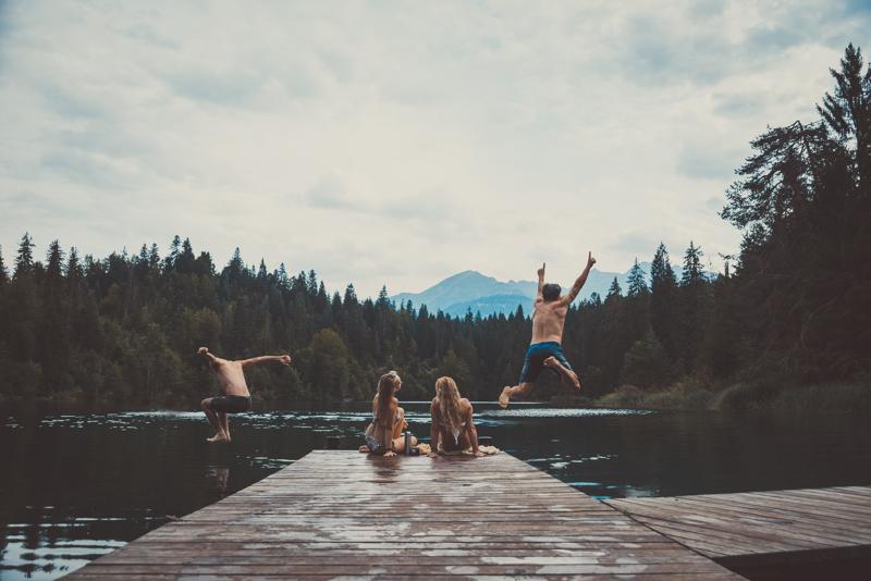Jumping Group of friends having fun at the lake in the morningGroup of friends having fun at the lake in the morning