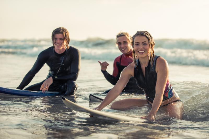 Surfer Clique Group of surfers chilling out on the beach. sitting on their boards and having fun